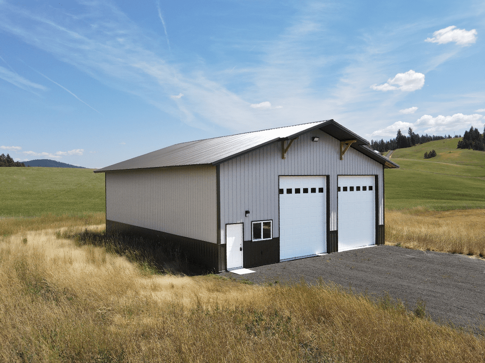 Brown shop with beige siding and dark brown roof, completed with white overhead garage doors