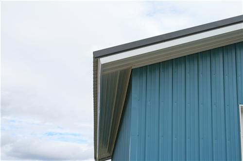 corner of a blue steel structure with 2' roof overhang