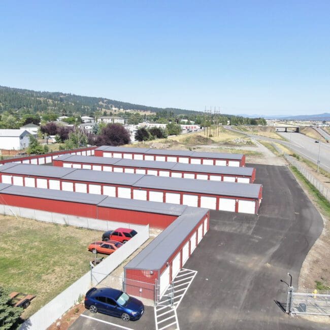 aerial view of a storage facility in Spokane, WA: red siding, grey roof, and white overhead doors