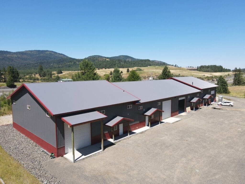 aerial view of a gray multi-use steel structure in Worley Idaho with red trim and white overhead garage doors