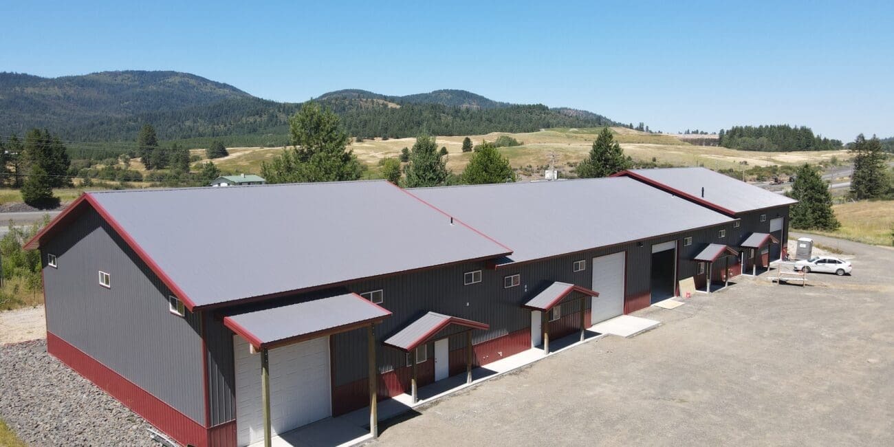 aerial view of a gray multi-use steel structure in Worley Idaho with red trim and white overhead garage doors