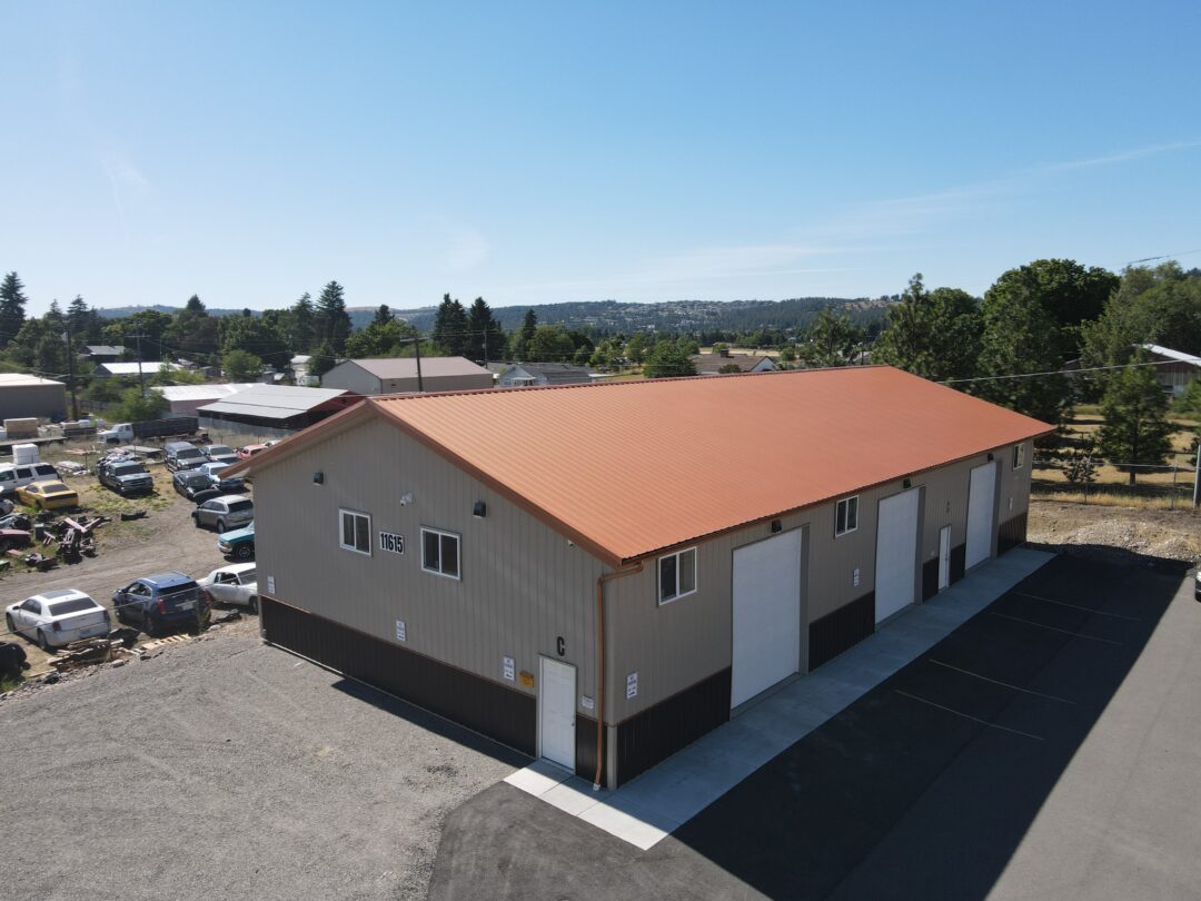 aerial view of steel structure commercial building with red roof and beige siding