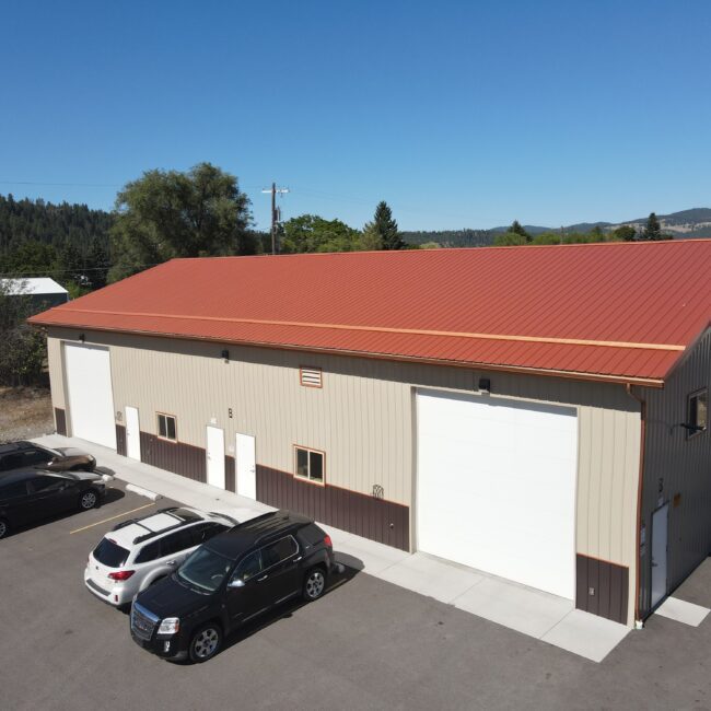 aerial view of steel structure commercial building with red roof and beige siding