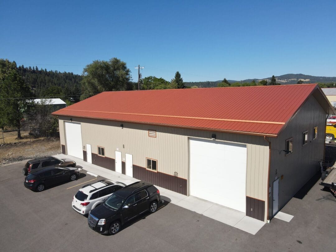 aerial view of steel structure commercial building with red roof and beige siding