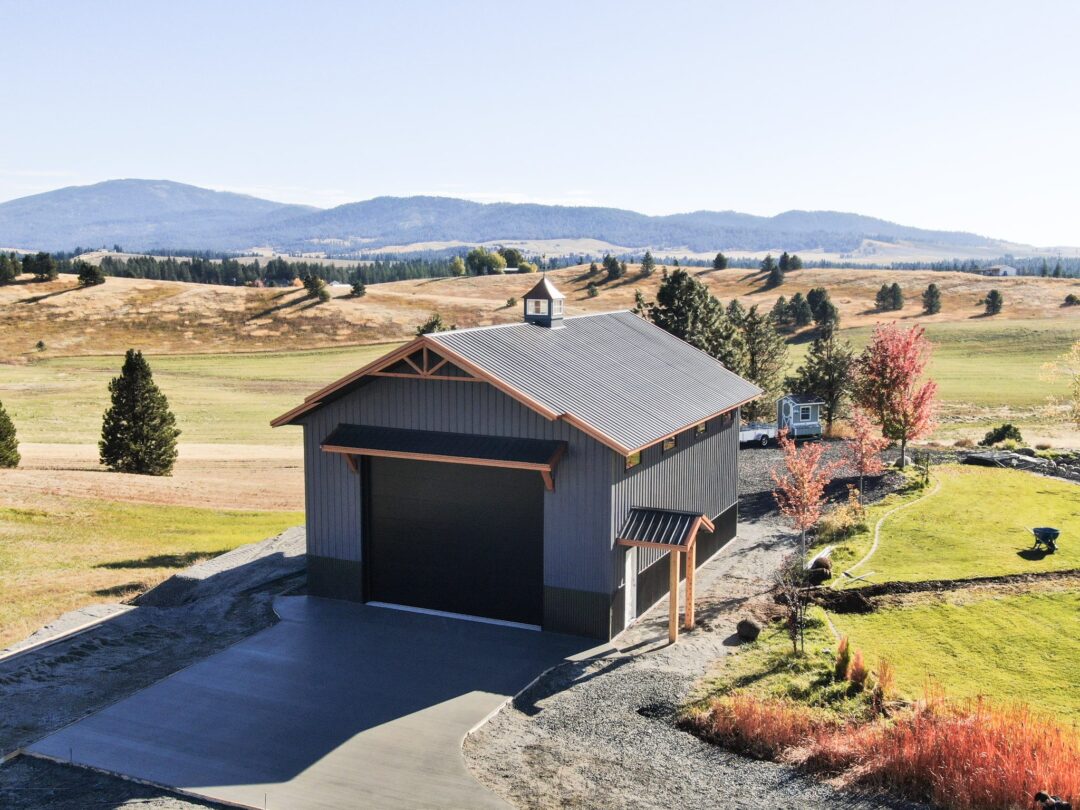 stylish charcoal gray building with copper styled steel roof and in the fall landscape