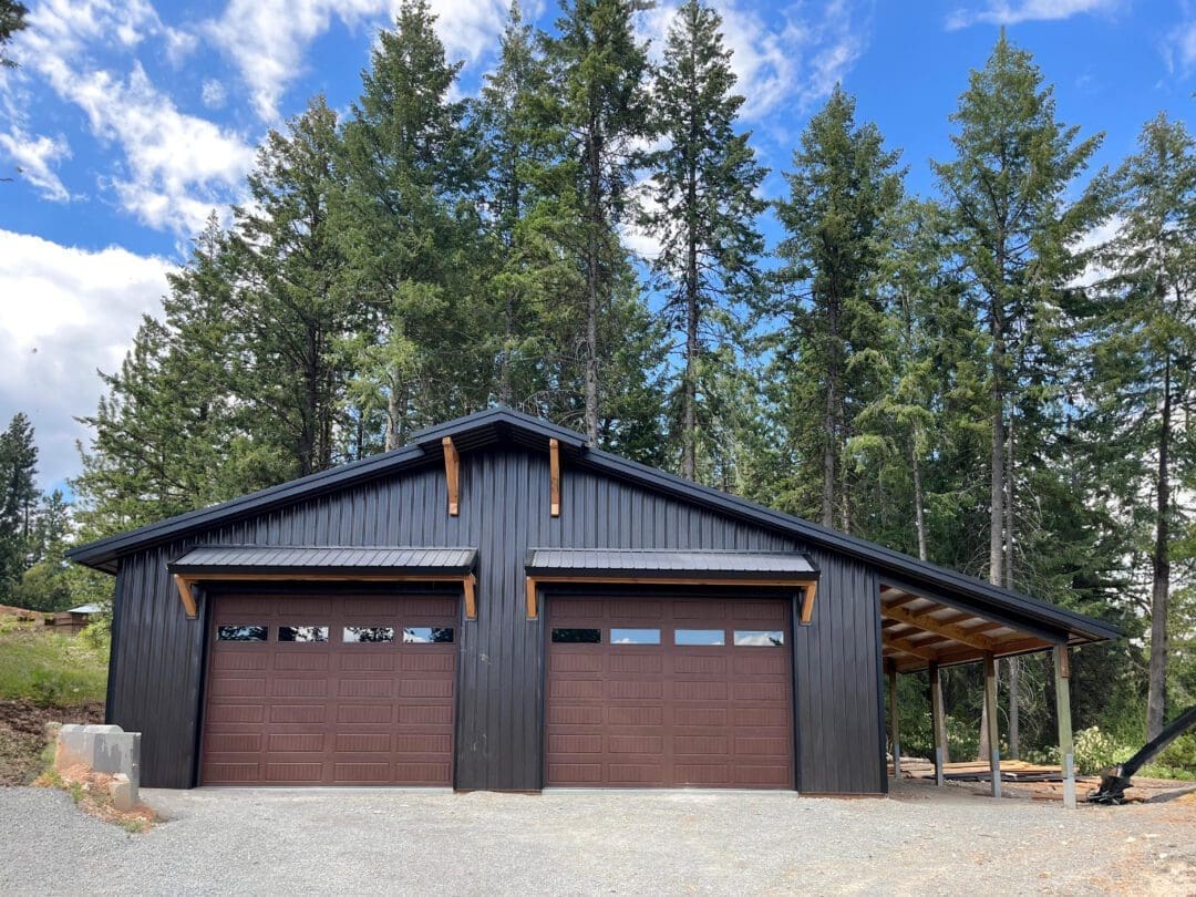 modern pole barn with wood corbels, brown garage doors and lean-to