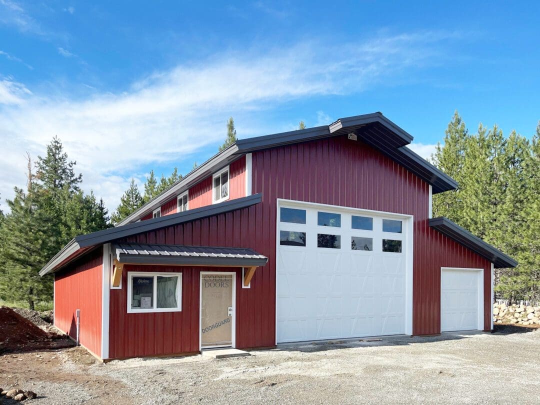 red monitor style barn with white garage doors
