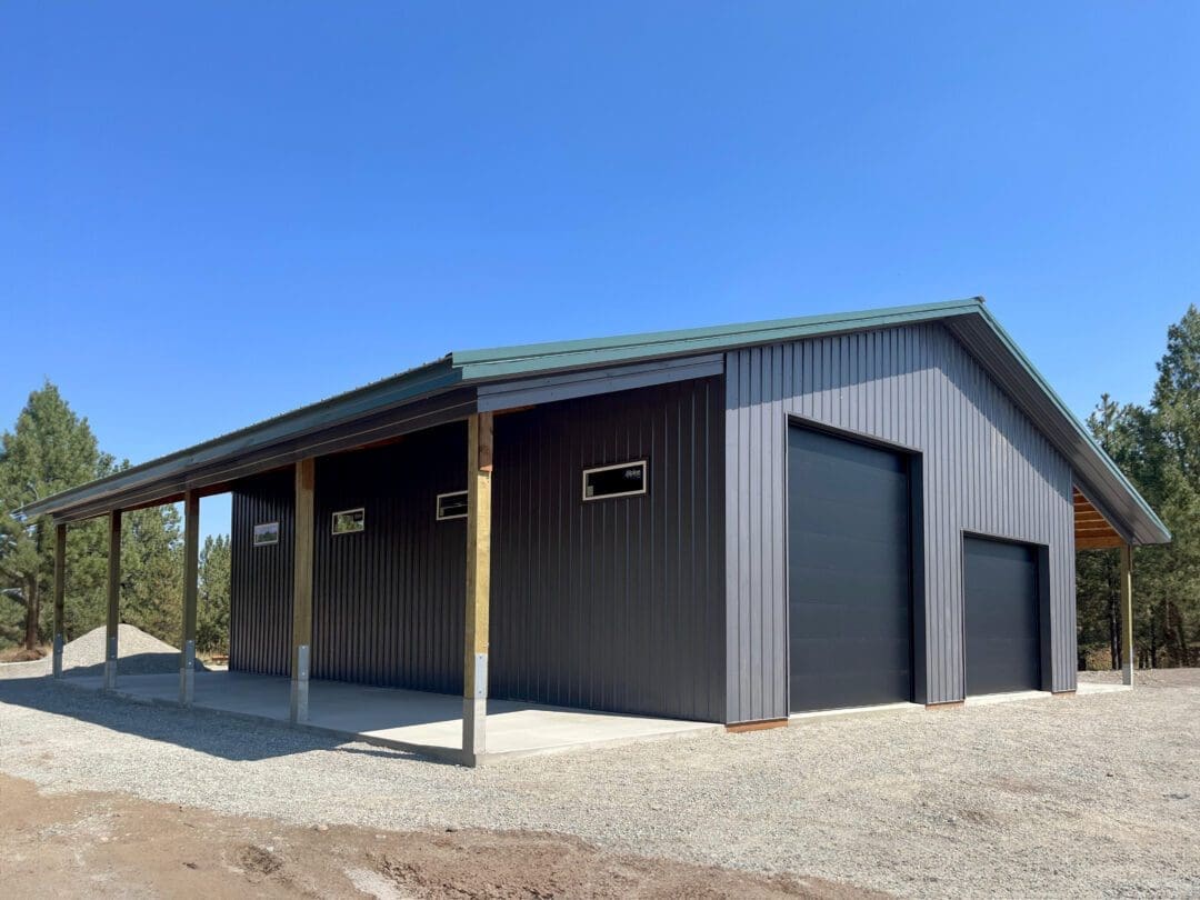 modern pole barn with wood corbels, brown garage doors and lean-to