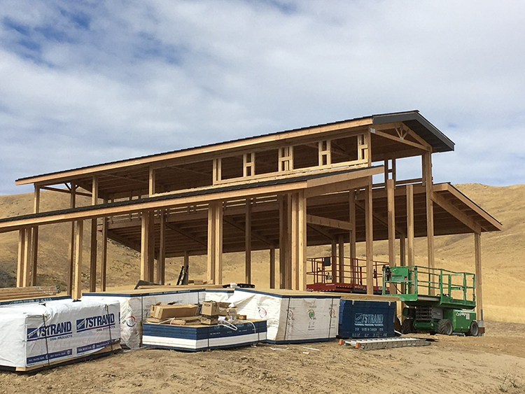 A monitor style pole barn workshop is at the rough framing stage of construction