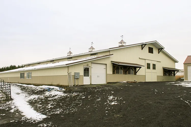 A swine barn used as a hog building in an agricultural setting, beige in color
