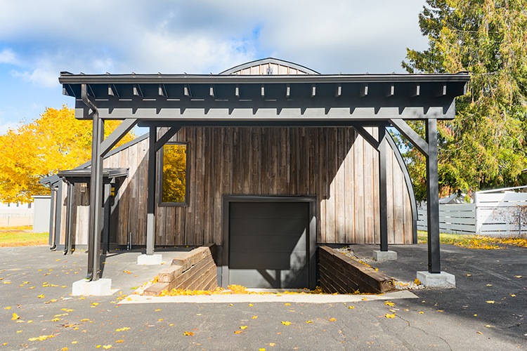 A lean-to provides a covered front porch for this small metal building