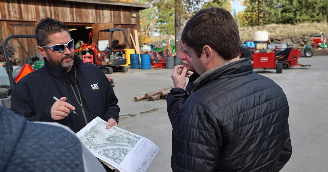 A post frame metal building contractor is discussing construction techniques with the homeowner