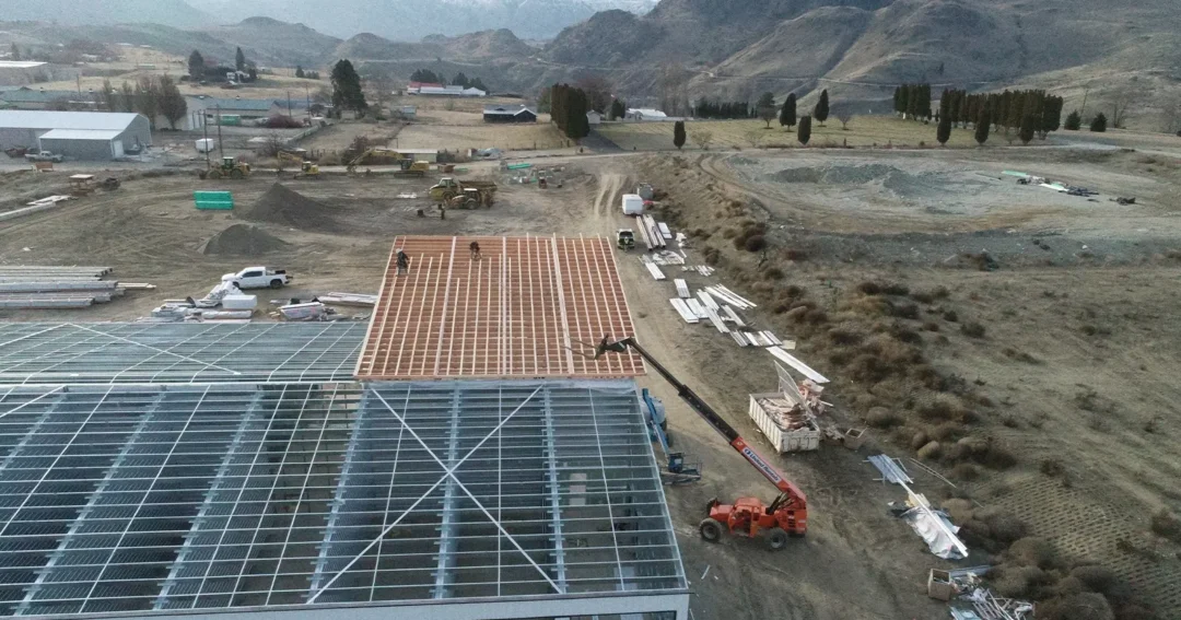 After recieving their metal building permits, these workers are constructing the building. There is a crane and workers