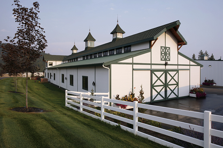 A beautiful white and green monitor pole barn built by Steel Structures America