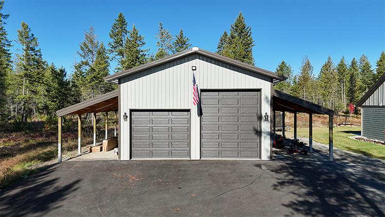 A metal building features two lean-to additions and large overhead doors