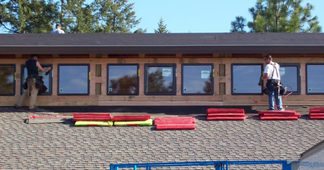 Pole barn windows are being installed by two workers