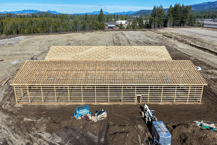 An image of an incomplete post frame building, showing the site being prepper for a foundation