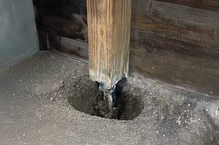 A rotted wood post in a pole barn