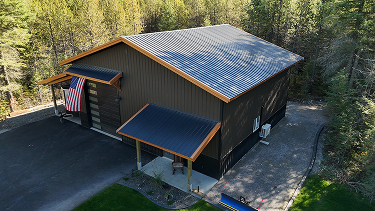 A shop building in a dark brown color with light tan trim