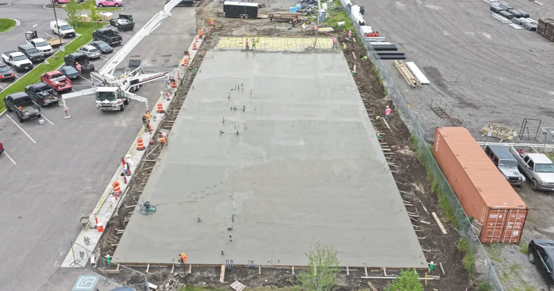 A pole barn conrete floor is being poured for the foundation of a shop